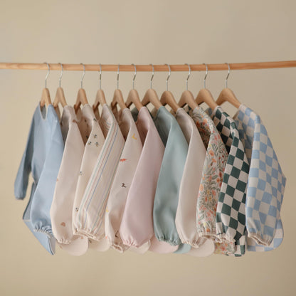 mushie Long Sleeve Baby Bib | Water Resistant Adjustable Fit for Ages 6-24 Months (Pastel Blooms)